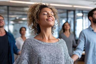 Sechs Personen bei der Ausführung von Entspannungsübungen in Büro.
